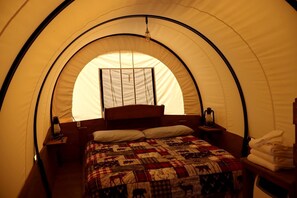 Ein Zelt mit Bett, Fenster, Laterne und Handtuch.