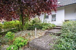 A garden with a variety of plants and a stone pathway leading to a building. - Apartment 'Haus 44 EG' with Lake View, Private Terrace and Wi-Fi (Röbel)