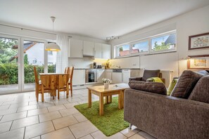 A modern apartment with a dining area, kitchen, and living room. - Apartment 'Haus 44 EG' with Lake View, Private Terrace and Wi-Fi (Röbel)