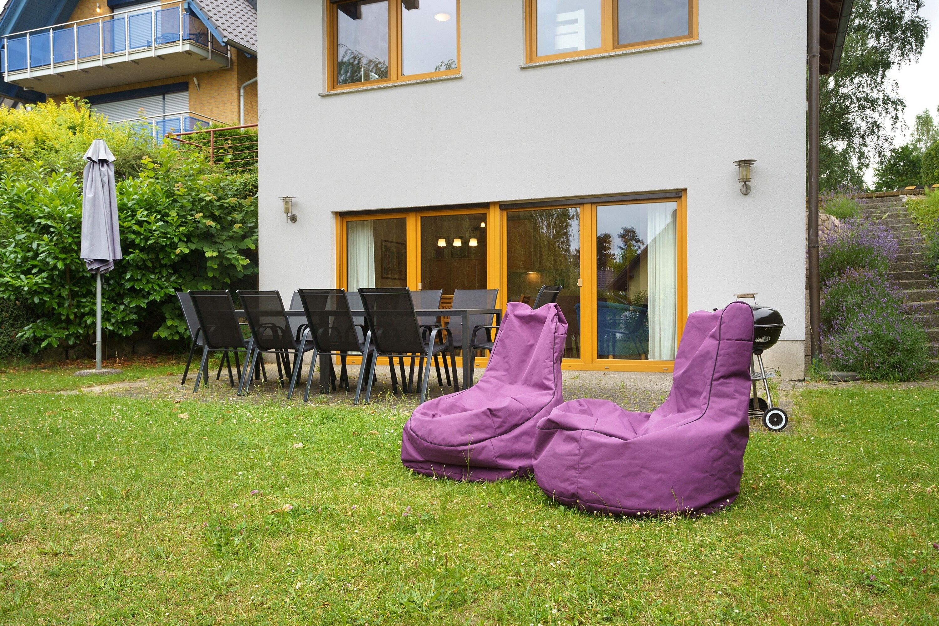 Une maison dotée d’un patio, d’un espace salon extérieur et d’un jardin.
