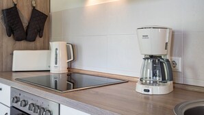 Een keuken met een koffiezetapparaat, een broodrooster en een fornuis.
