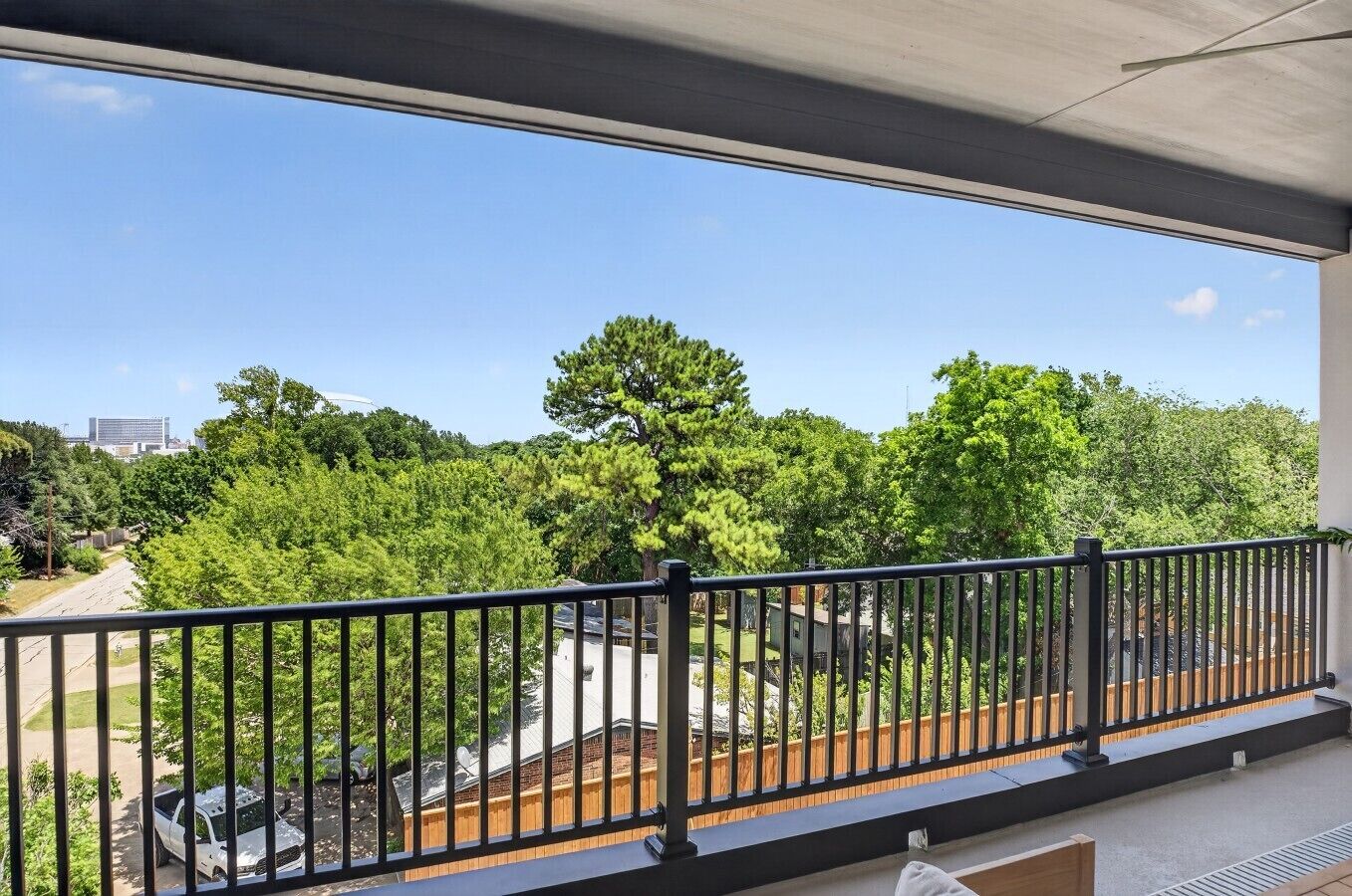 Een balkon met uitzicht op een groen landschap en een gebouw in de verte.