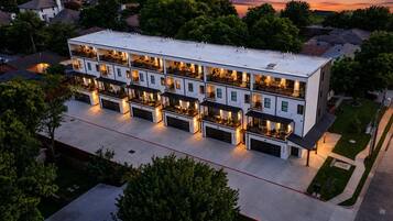 A multi-story hotel with balconies and outdoor seating areas.