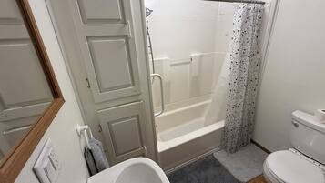 A bathroom with a bathtub, toilet, and shower.