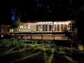 A building with a covered patio area, potted plants, and outdoor seating. - BeachyBu 3-bedroom Michiana cottage 2 blocks to Lake (New Buffalo)