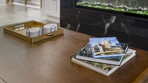 A table with a tray holding plates and a stack of books titled 'DALLAS, TEXAS'. - Luxury Townhome A. Walk to AT&T Stadium. Rooftop Terrace + Game Room. Sleeps 10. (Arlington)