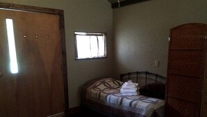 A small bedroom with a single bed, a window, a wardrobe, and a door. - Secluded Family-Friendly Log Cabin Rental for Families near Helena (Hall)