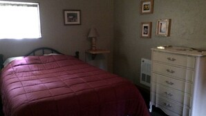 A bedroom with a bed, a dresser, and a window. - Secluded Family-Friendly Log Cabin Rental for Families near Helena (Hall)