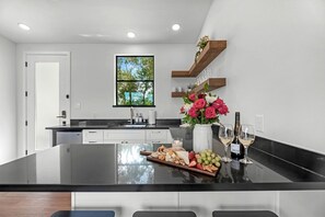A modern kitchen with a central island, a window with a view, and built-in shelves.