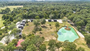A large, open area with multiple buildings, a central water feature, and surrounding greenery.