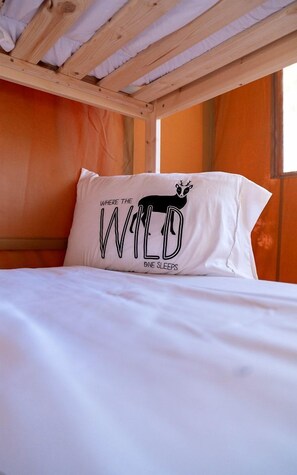 Ein Bett mit einem Kopfkissen, das ein Tierdesign und Text aufweist.