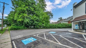 Een parkeerplaats met blauwe parkeerplaatsen voor mindervaliden en een gebouw met een duidelijke ingang.