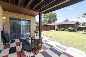 A covered patio with a checkered floor, a table, chairs, and a grill. - Spacious Dallas Stay Near Downtown Attractions (Dallas)