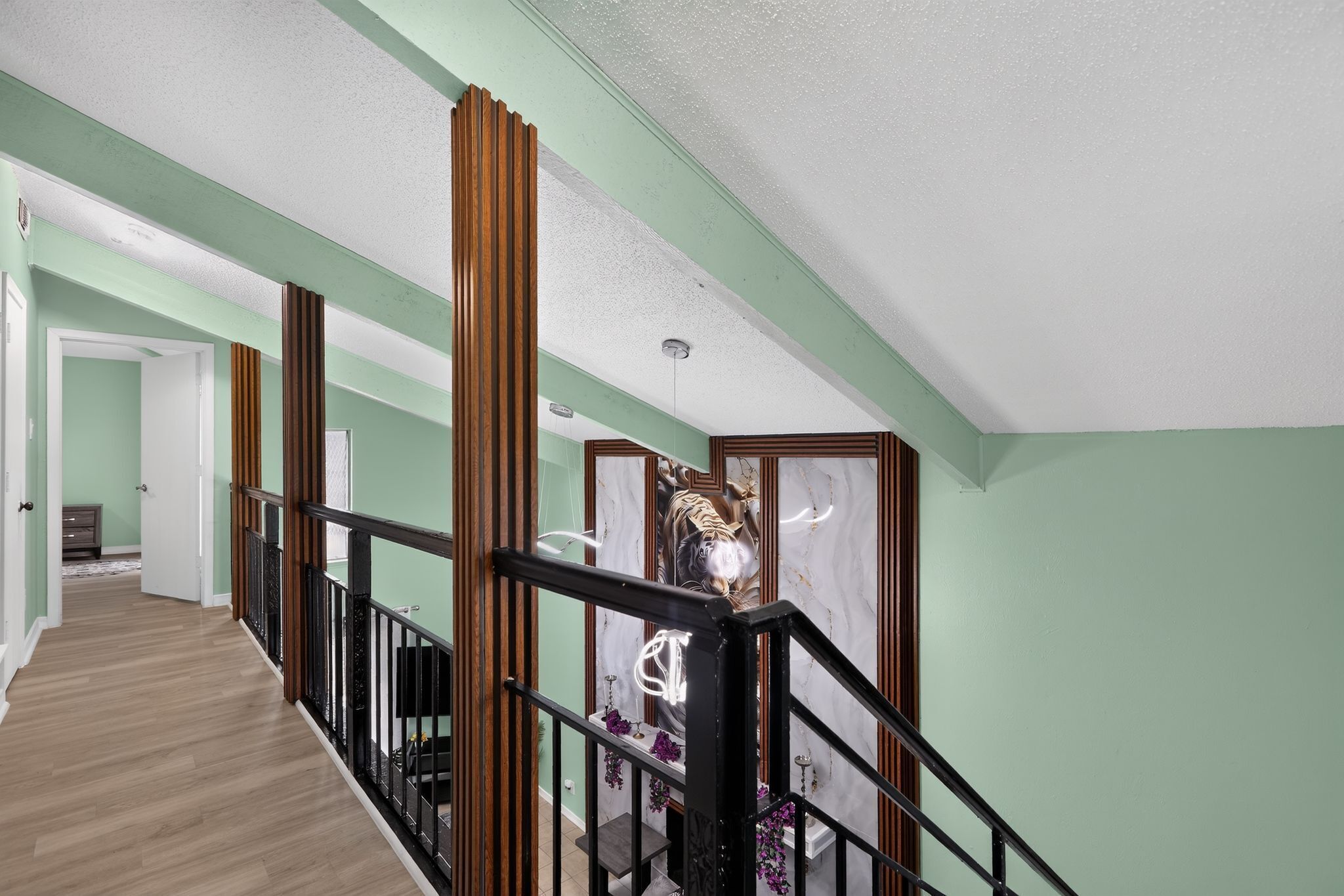 A staircase with a wooden railing, a marble wall, and a door at the top.