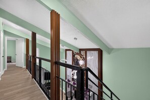 A staircase with a wooden railing, a marble wall, and a door at the top. - Spacious Dallas Stay Near Downtown Attractions (Dallas)