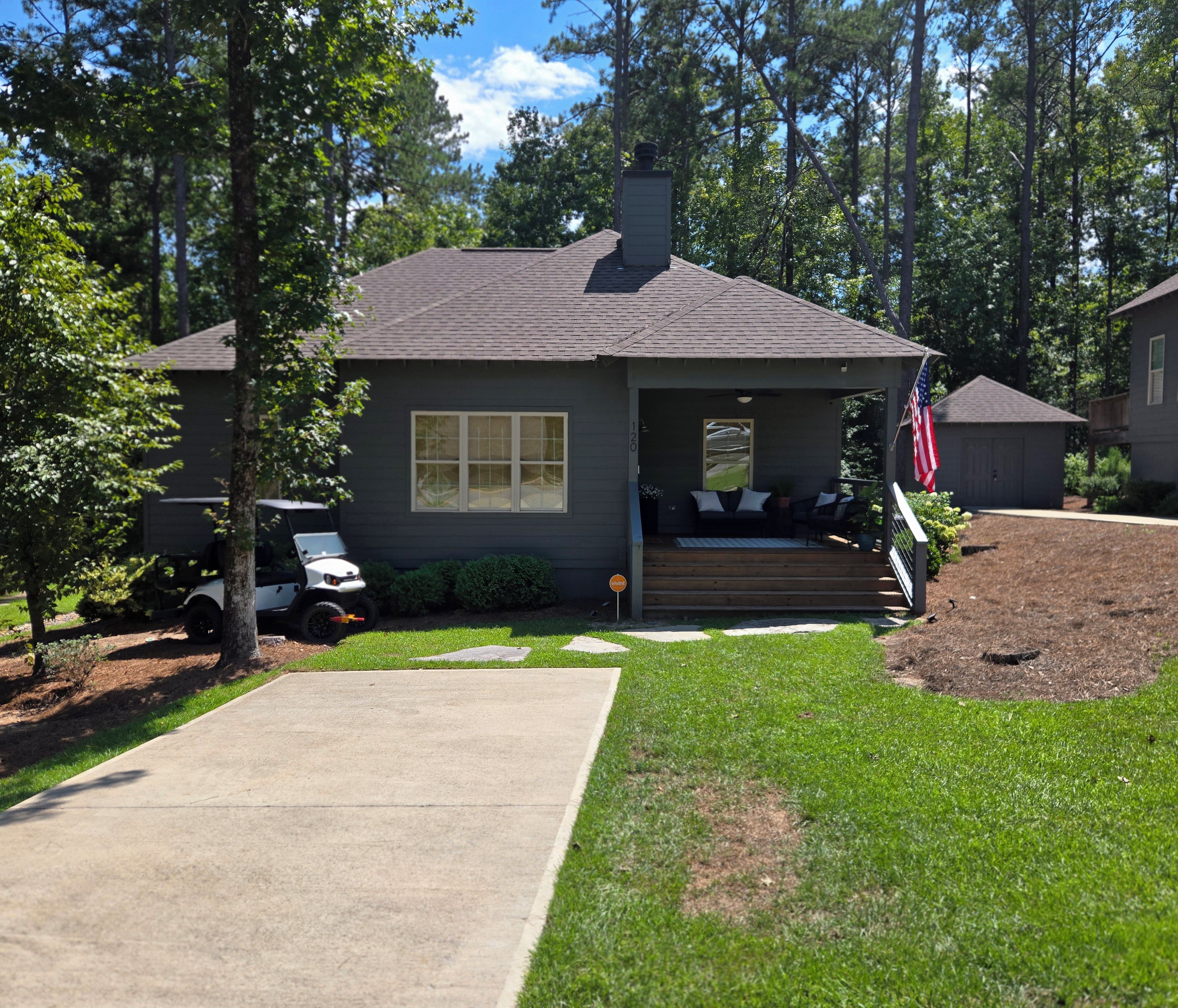 A residential house with a front porch, a driveway, and a lawn.