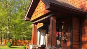 Une cabane en bois avec une véranda, des marches en pierre et un jardinière en pierre.