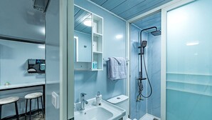 Een moderne badkamer met een wastafel, spiegel, handdoekhouder en douche.