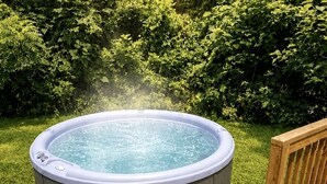 Een hottub op een houten terras, met een trap ernaartoe.