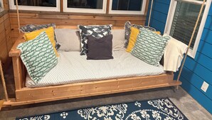 Un banc en bois avec des coussins et un mur bleu.