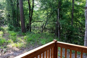 A wooden deck with a view of a forested area. - Fantastic Tranquil Cabin with Barbecue in Livingston, Texas (Livingston)