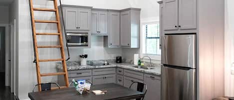 Coffee/tea maker, fridge, stovetop, cookware/dishes/utensils