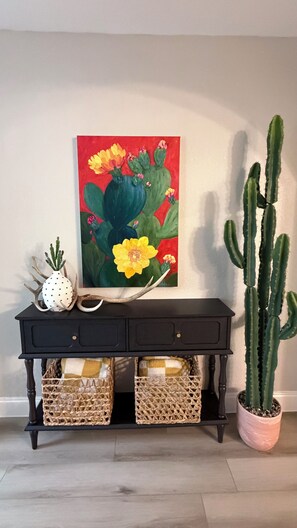 A black console table with two woven baskets, a white polka-dotted vase, and a cactus plant. - Echo Meadow Hideaway: Your Peaceful Escape (Spring Branch)
