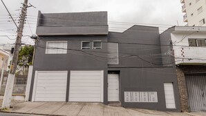 Un bâtiment moderne à deux étages, doté d’un garage, d’une petite fenêtre et d’une porte.
