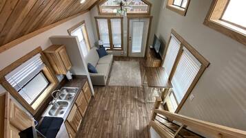 A compact kitchen with wooden cabinetry, a built-in sink, and a dining area with a table and chairs.