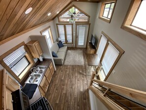 Une cuisine compacte dotée de meubles en bois, d’un évier encastré et d’un coin repas avec une table et des chaises.
