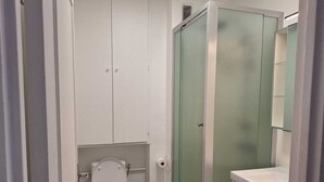 Un bany petit i funcional amb lavabo, vàter i plat de dutxa.