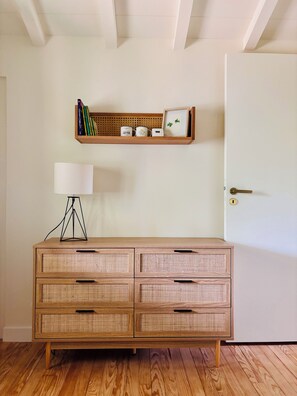 A room with a wooden dresser, a white door, and a shelf with books and decorative items. - Le Canon – Beautiful, renovated villa in the Landes region with a pool – Sleeps 10 – Beach within walking distance (Lège-Cap-Ferret)