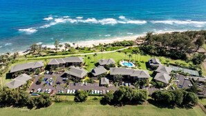 Eine Luftaufnahme eines Resorts mit mehreren Gebäuden, einem Pool und einem Strand.