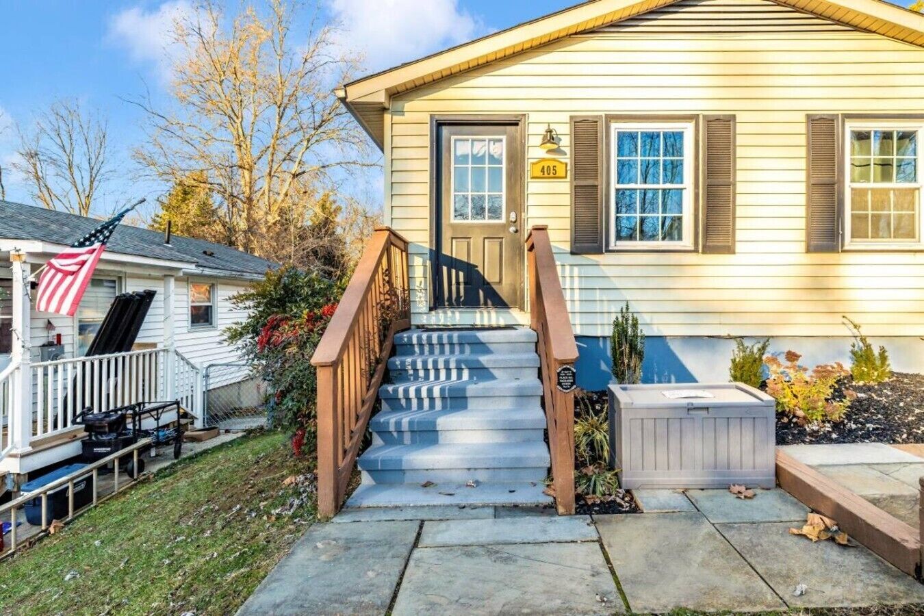Ein zweistöckiges Haus mit Veranda, Treppe und Briefkasten.