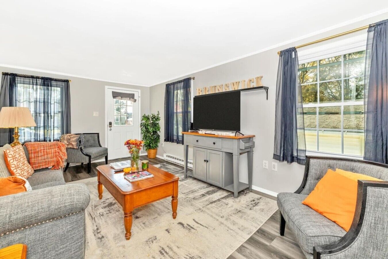 A living room with a grey sofa set, a coffee table, a TV, and a cabinet.