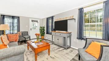 A living room with a grey sofa set, a coffee table, a TV, and a cabinet.