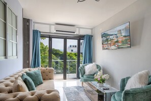 A modern living room with a sofa, armchairs, a coffee table, and a painting of a cityscape. - Stylish Cali Apartment with  City Views (Cali)