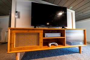 A wooden entertainment center with a television, a gaming console, and a DVD player. - Lakefront Tiny Home Retreat with Private Dock & Sunset Views in Tracy City, Tennessee (Tracy City)