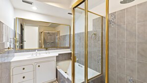 A modern bathroom with a glass shower enclosure, a bathtub, and a vanity with a mirror. - Tasman Towers - Unit 6 - Ocean Views (The Entrance)