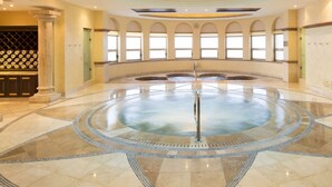 Jacuzzi rodó amb sòl de rajola, finestres d'arc i una porta de fusta.