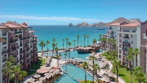 Un complex turístic amb diverses piscines, palmeres i vista a l'oceà.
