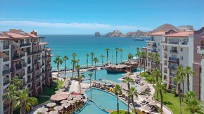 A resort with multiple swimming pools, palm trees, and a view of the ocean. - 2 Bedroom Luxury suite Oceanfront Resort in marvelous Cabo San Lucas (Cabo San Lucas)
