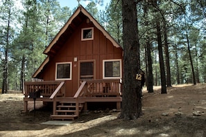 A cabin with a wooden exterior, a porch, and a number '12' sign. - Relaxing Cabin Perfect to Disconnect and Recharge in Arizona (Flagstaff)