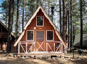 A cabin with a number 19 sign, a porch, and a chimney. - Remodeled A-Frame Cabin Perfect for a Romantic Escape in Arizona (Flagstaff)
