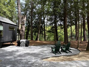 A campsite with a covered area, a small building, and a gravel ground. - Waterfront Adirondack Tiny Cabin Near Lake George & Saratoga Springs, New York (Corinth)