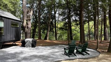 Um camping com área coberta, um pequeno edifício e piso de cascalho.