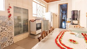 A kitchen with a dining table, a refrigerator, a coffee machine, and a water dispenser.
