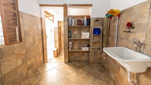 Ein Badezimmer mit Waschbecken, Dusche und Ablage für Toilettenartikel.