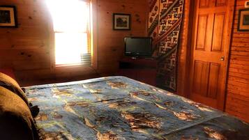Una habitación con cama, televisión, ventana y puerta.
