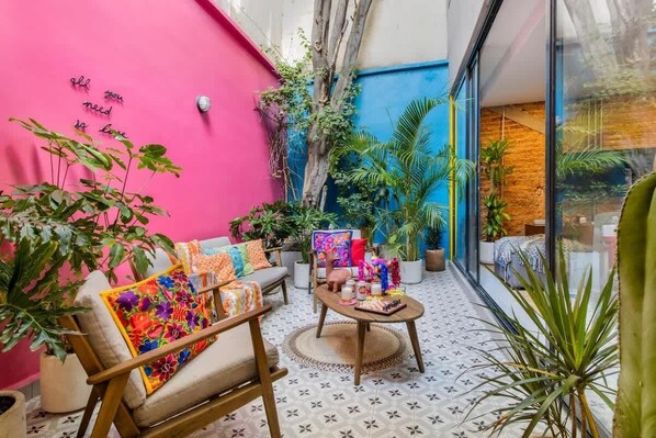 A cozy indoor space with a sofa, a coffee table, and potted plants.